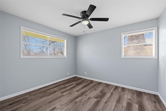 unfurnished room with baseboards, dark wood finished floors, and a ceiling fan