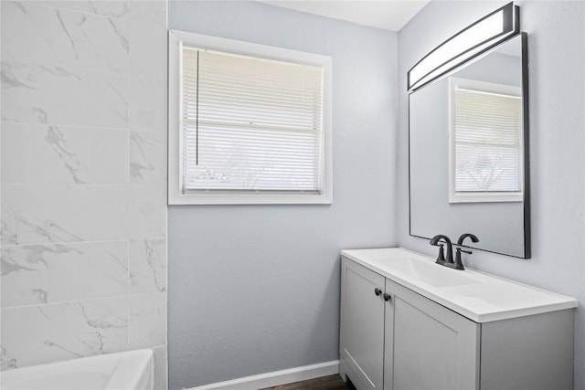 bathroom with vanity, shower / tub combination, and baseboards