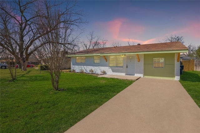 ranch-style house with brick siding, a front lawn, and fence