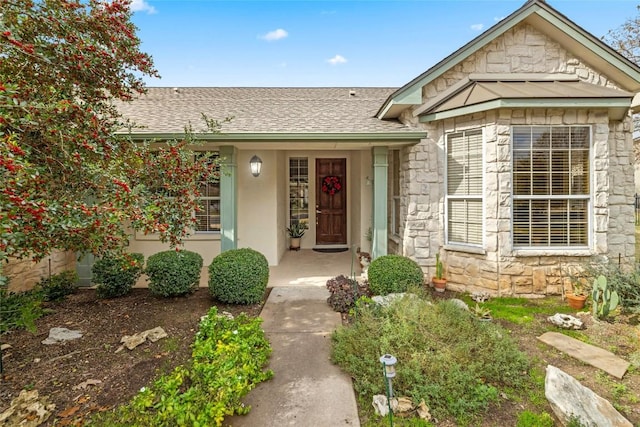 entrance to property with stucco siding, stone siding, covered porch, and a shingled roof