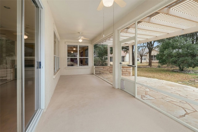 unfurnished sunroom featuring a ceiling fan