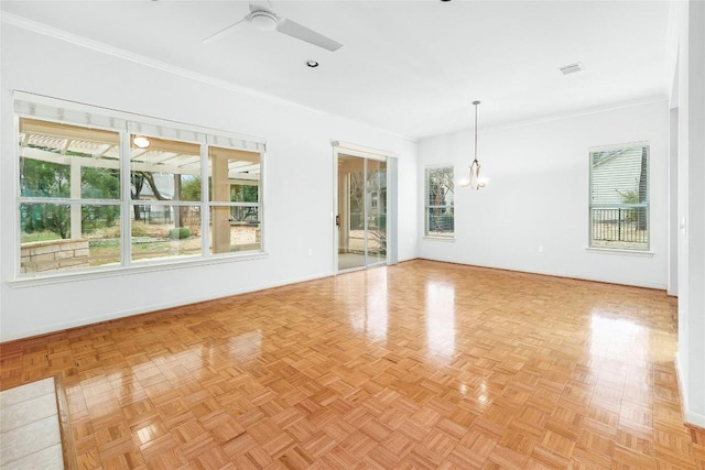 empty room featuring visible vents, ornamental molding, and ceiling fan with notable chandelier