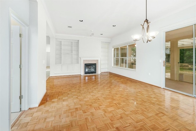 unfurnished living room with a tiled fireplace, built in shelves, visible vents, and baseboards