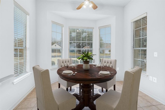 dining room with light tile patterned floors, a ceiling fan, and baseboards