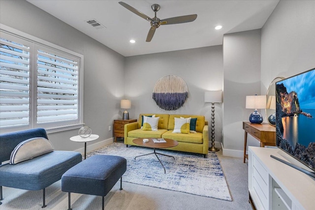 living room with visible vents, carpet floors, baseboards, and ceiling fan