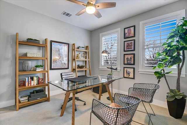 carpeted office space with visible vents, ceiling fan, and baseboards