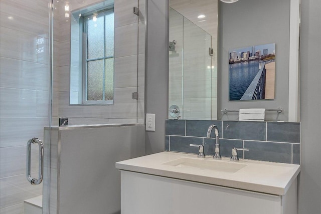 full bathroom with tasteful backsplash, a stall shower, and vanity