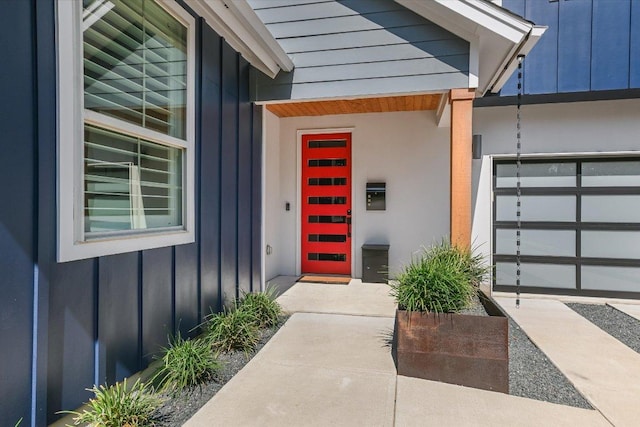 doorway to property with a garage and board and batten siding