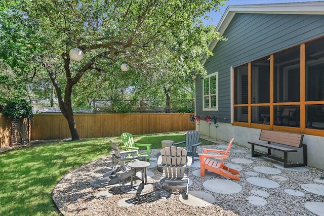 exterior space with a fire pit, fence, and a sunroom