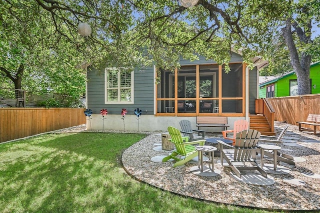 back of property featuring a fire pit, a sunroom, a yard, a fenced backyard, and a patio