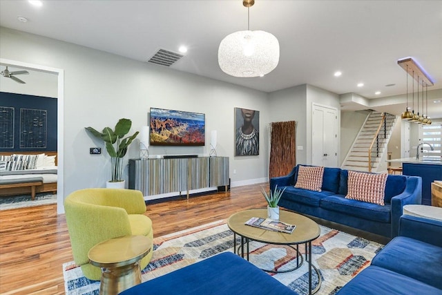 living room with visible vents, baseboards, stairs, recessed lighting, and wood finished floors