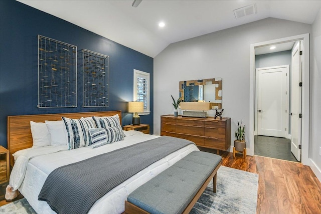 bedroom featuring visible vents, wood finished floors, recessed lighting, baseboards, and vaulted ceiling