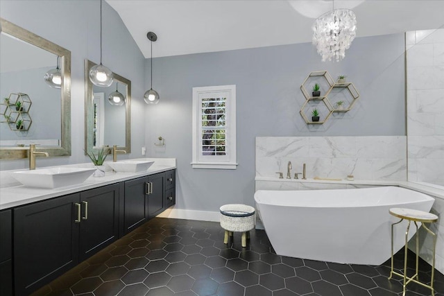 bathroom featuring a freestanding bath, lofted ceiling, double vanity, and a sink