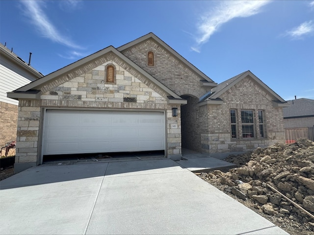 view of front of house featuring brick siding, driveway, and an attached garage