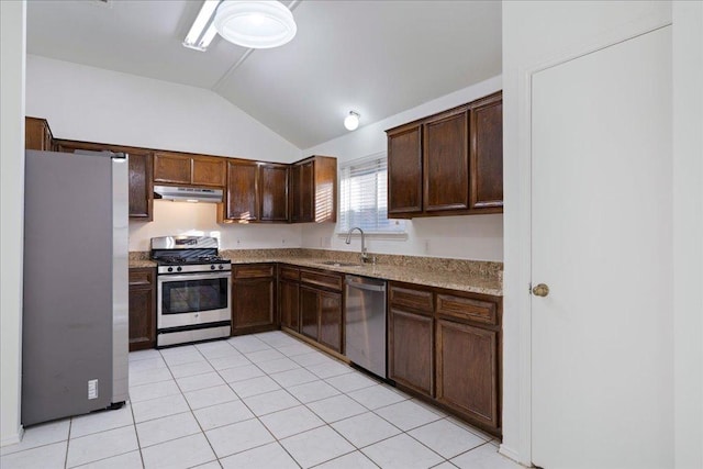 kitchen featuring under cabinet range hood, vaulted ceiling, light stone counters, stainless steel appliances, and a sink