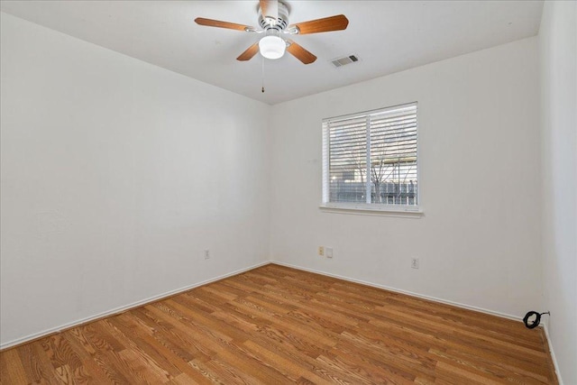 spare room featuring visible vents, light wood-style floors, and ceiling fan