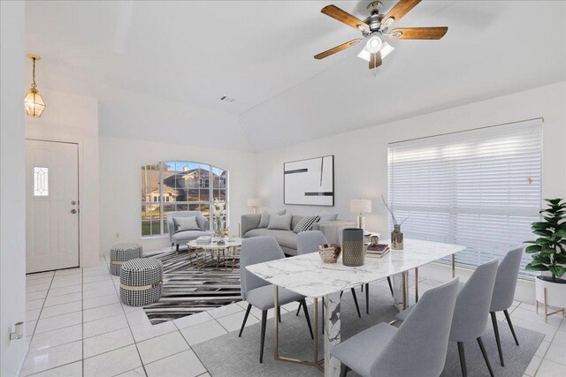 dining area with lofted ceiling, light tile patterned flooring, and ceiling fan