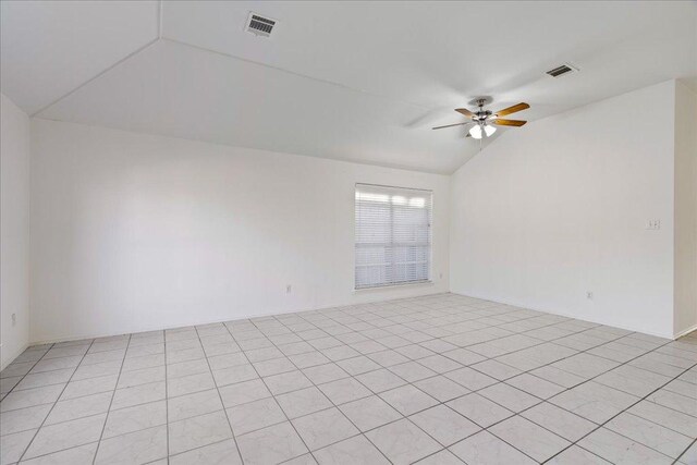 empty room with vaulted ceiling, a ceiling fan, and visible vents