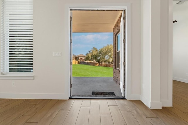 doorway to outside featuring wood finished floors and baseboards