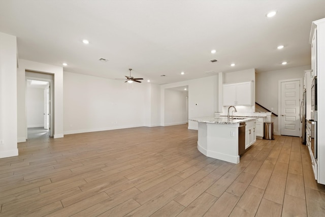 kitchen with a center island with sink, light wood-type flooring, recessed lighting, a sink, and open floor plan