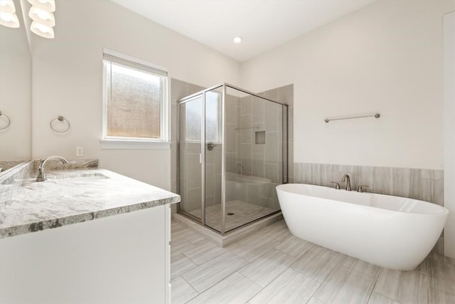 bathroom with a freestanding tub, vanity, wainscoting, and a shower stall