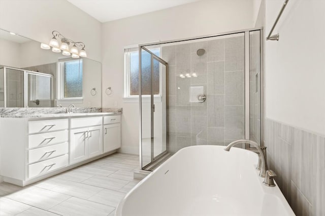 bathroom featuring a soaking tub, a stall shower, and vanity