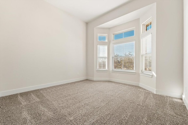 carpeted empty room featuring baseboards