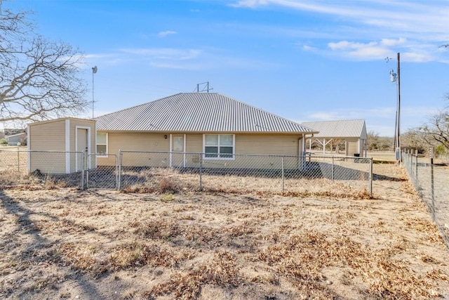 back of property featuring metal roof and fence