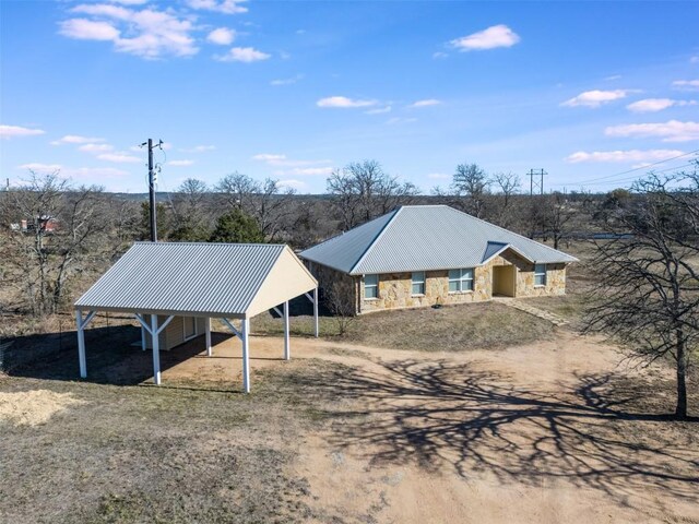 exterior space with a carport and dirt driveway