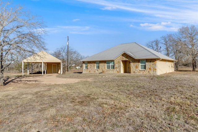 view of front of home with stone siding, metal roof, and dirt driveway