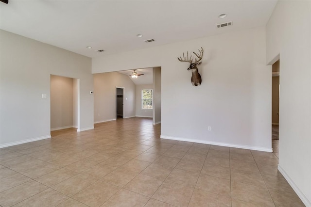 empty room with light tile patterned floors, visible vents, a ceiling fan, and vaulted ceiling