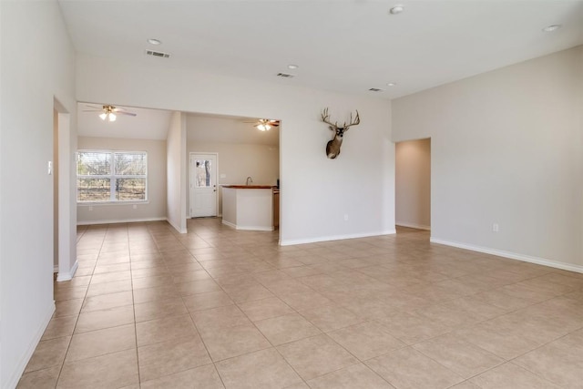 empty room with visible vents, baseboards, and ceiling fan