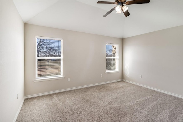 carpeted spare room featuring ceiling fan, baseboards, and vaulted ceiling