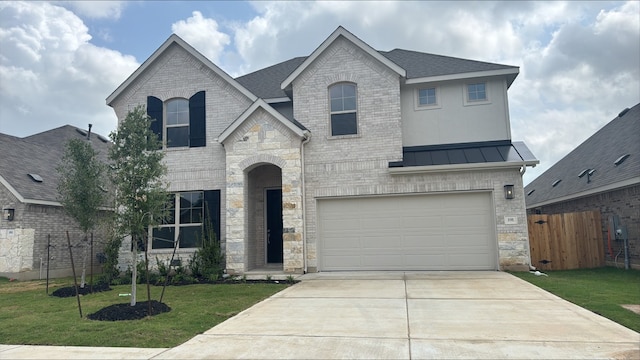 191 Dove Tree Dr, Buda, TX 78610 - french country inspired facade featuring a front yard, driveway, stone siding, an attached garage, and fence