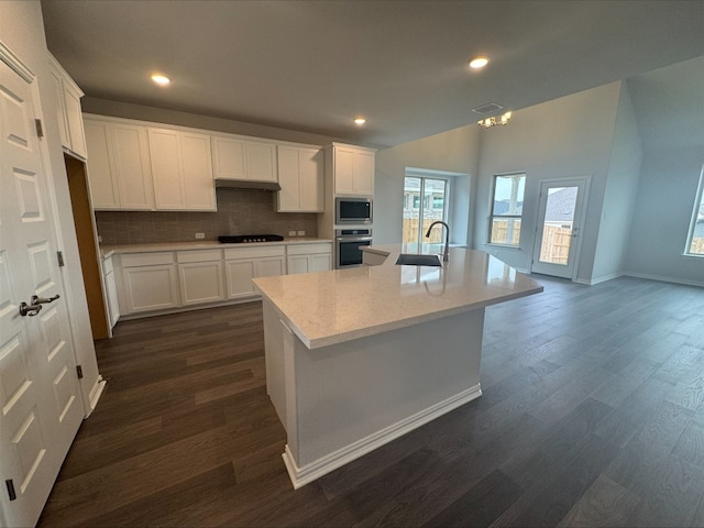 191 Dove Tree Dr, Buda, TX 78610 - kitchen with light countertops, appliances with stainless steel finishes, dark wood-type flooring, and decorative backsplash