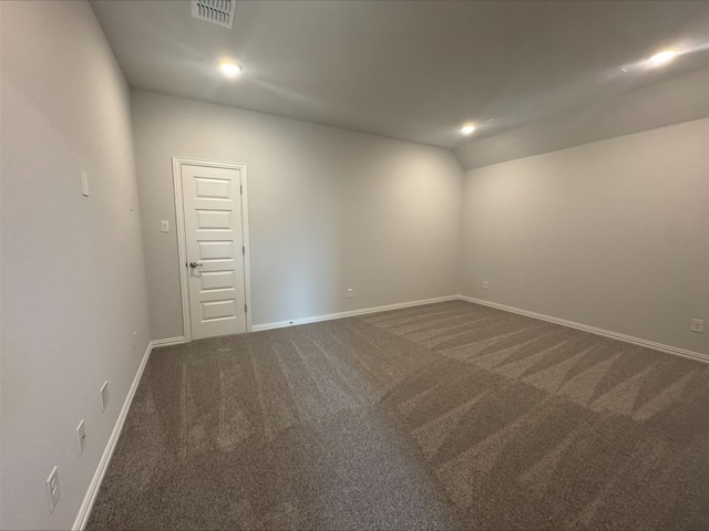 191 Dove Tree Dr, Buda, TX 78610 - empty room featuring recessed lighting, visible vents, dark colored carpet, baseboards, and lofted ceiling