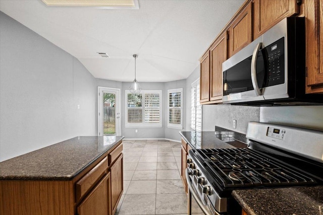 kitchen with visible vents, backsplash, stainless steel appliances, dark stone counters, and brown cabinetry