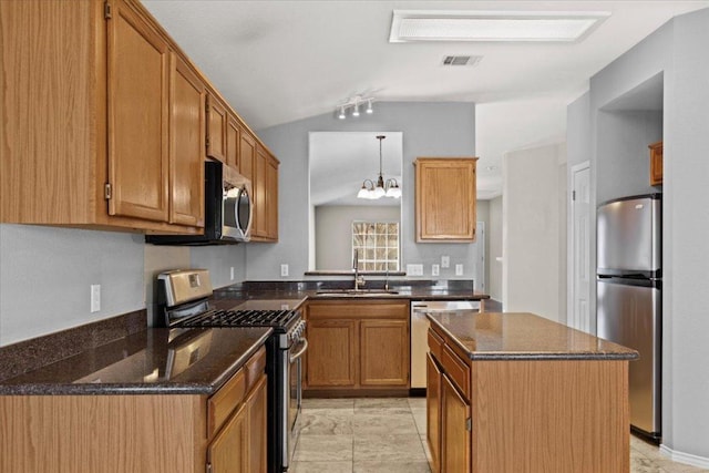 kitchen with visible vents, a kitchen island, a sink, vaulted ceiling, and appliances with stainless steel finishes