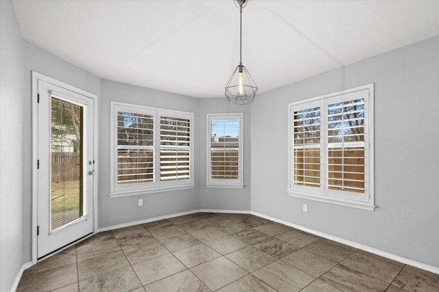 unfurnished dining area featuring a healthy amount of sunlight and baseboards