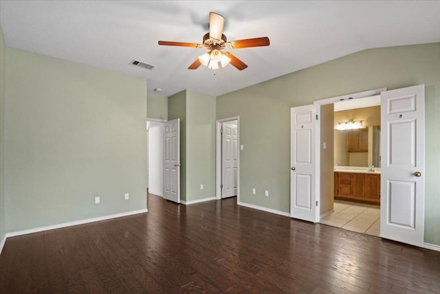 unfurnished bedroom with visible vents, baseboards, lofted ceiling, and wood finished floors