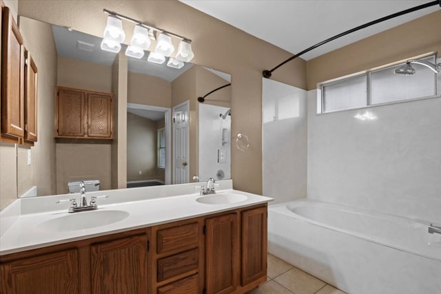 bathroom featuring tile patterned flooring, toilet, bathtub / shower combination, and a sink