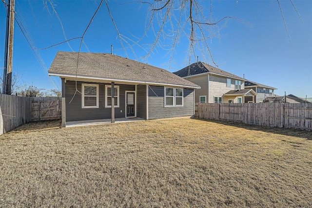 rear view of house with a patio, a fenced backyard, a lawn, and a shingled roof