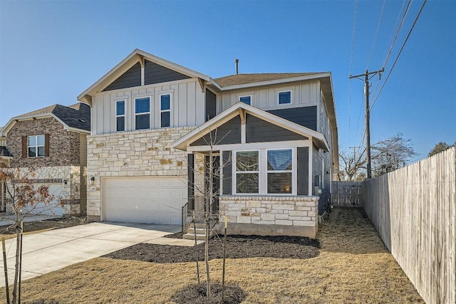 view of front of property with driveway, stone siding, fence, board and batten siding, and a garage