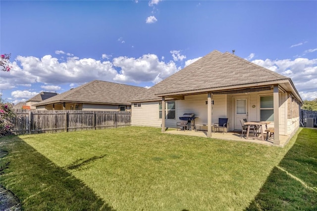 rear view of house featuring a patio, a yard, and a fenced backyard