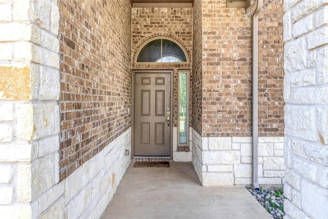 entrance to property featuring brick siding