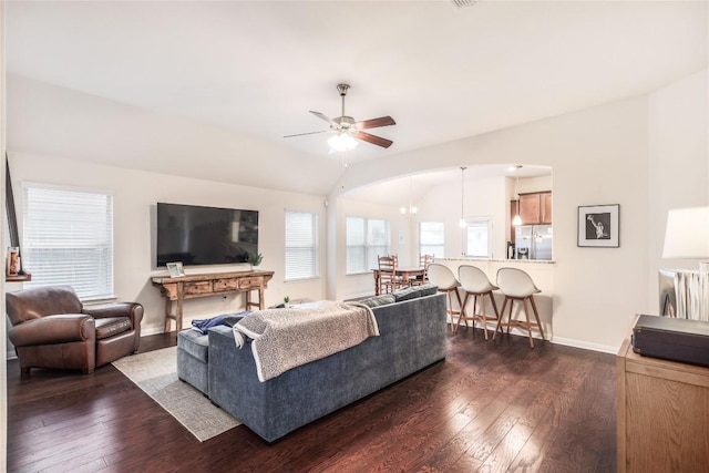 living room featuring vaulted ceiling, dark wood-style floors, and a healthy amount of sunlight