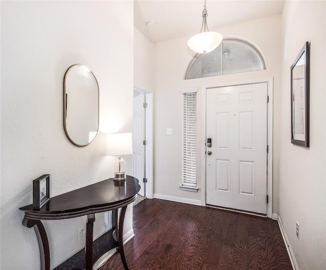 entrance foyer with dark wood-style floors and baseboards