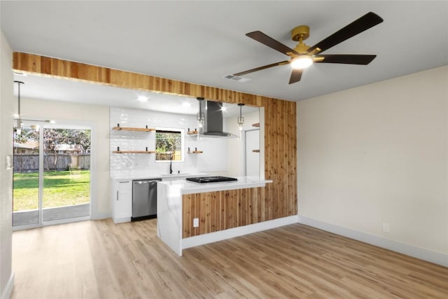 kitchen featuring dishwasher, open shelves, wall chimney range hood, and light wood-style floors