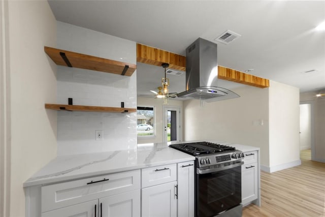 kitchen with visible vents, gas range, island range hood, a ceiling fan, and open shelves