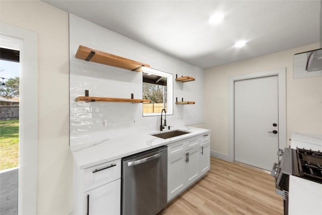 kitchen with light wood finished floors, open shelves, white cabinets, stainless steel appliances, and a sink